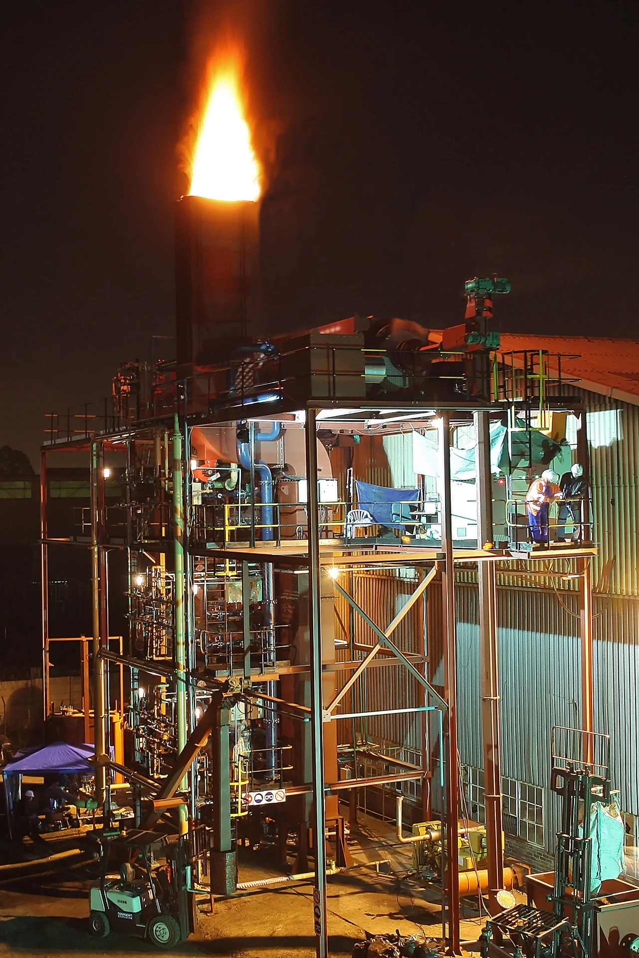 Flash pyrolysis plant operating at night with flare stack