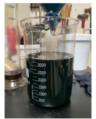 Raw pyrolysis oil sample in a measuring beaker